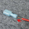 A blue T-tap wire connector with a gold-colored tip and a red brush is shown on a gray, fuzzy surface.