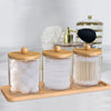 Acrylic bathroom storage set with bamboo lids containing white bath salts and wooden scoops