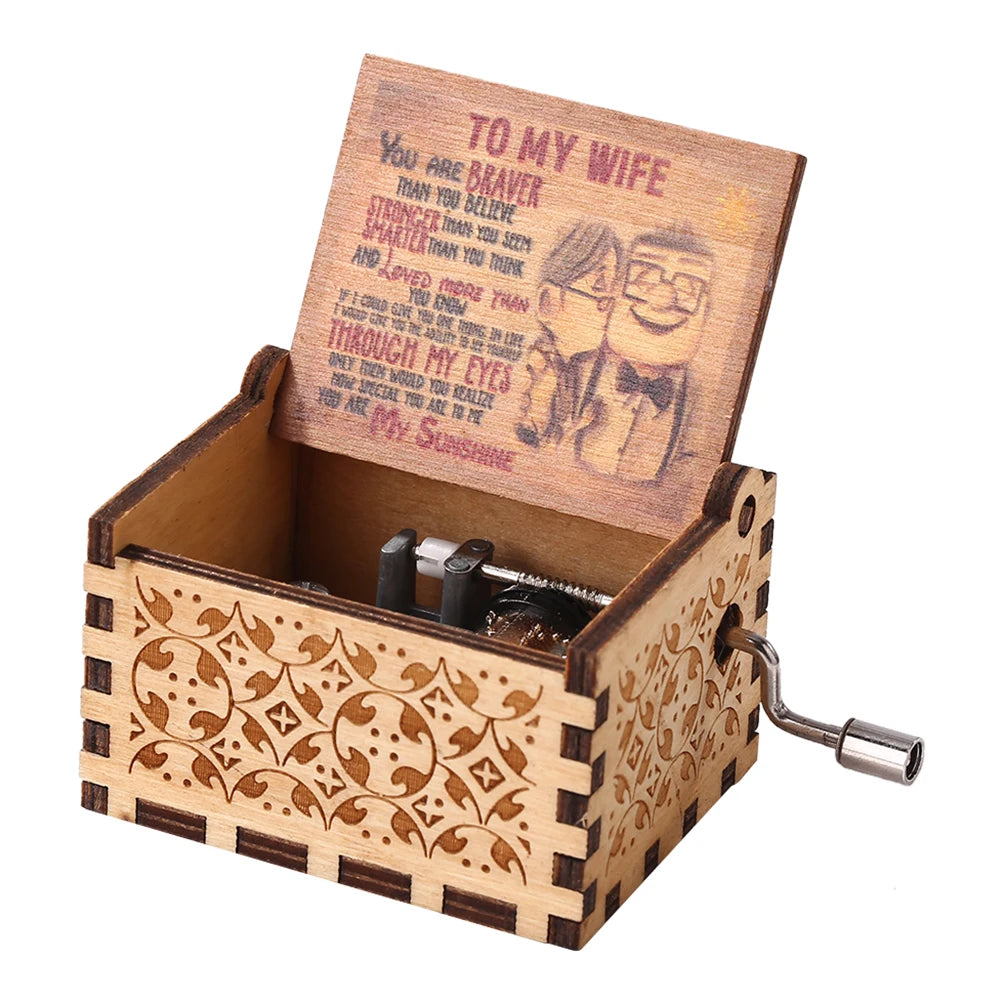 A hand-cranked wooden music box featuring a card with the text You Are Braver Than You Believe and My Sunshine.
