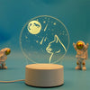 A glowing 3D illusion LED night light lamp showing a moon and a cat silhouette against a blue background.
