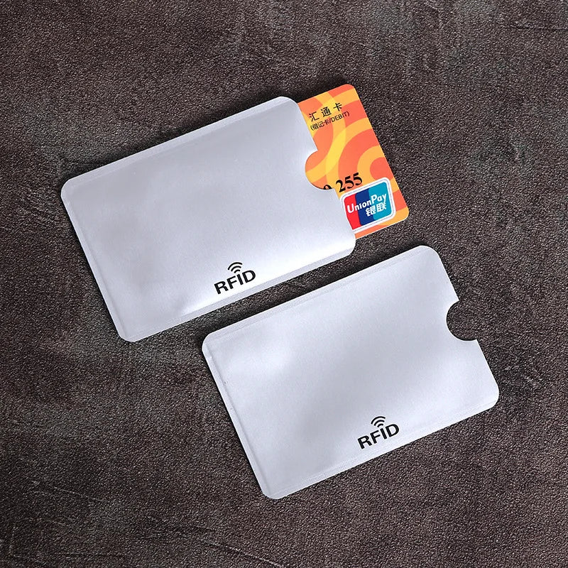 A set of ten clear plastic RFID blocking card sleeves is displayed on a dark surface.