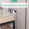 A foldable laundry basket with a large capacity and waterproof oxford cloth is shown next to a bedside table.