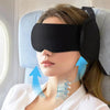 A woman is wearing a black sleep mask and neck pillow with adjustable head support for travel or sleep.