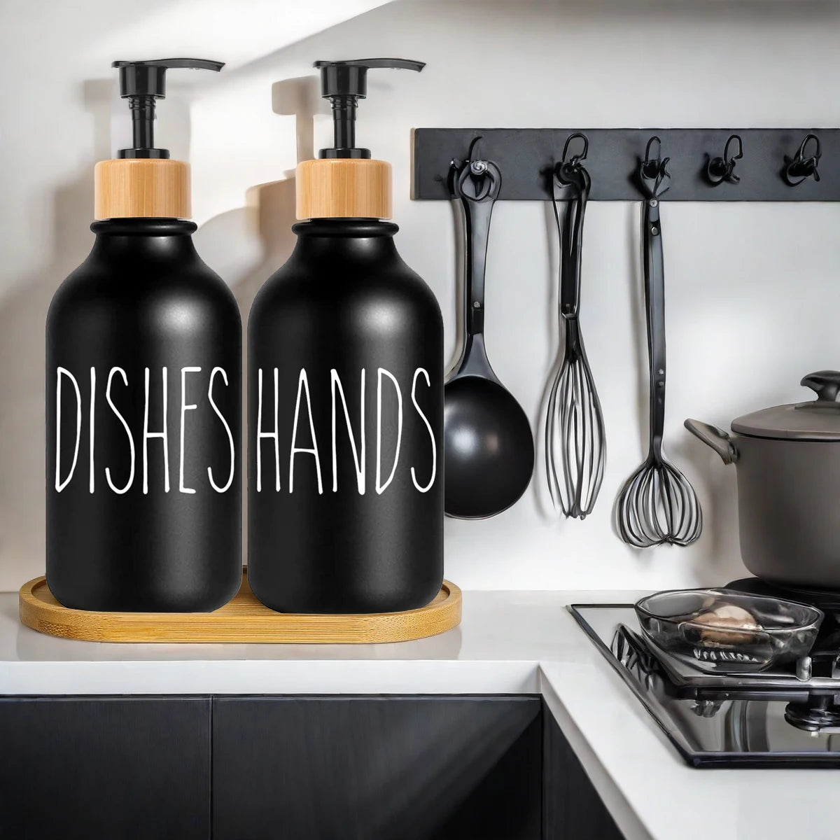 Black pump dispensers for dishes and hands with wooden accents hanging on a kitchen rack