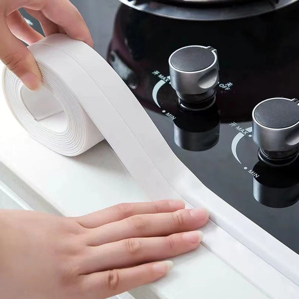 A hand is unwinding a roll of white waterproof self-adhesive sealing tape near a black pot on a stovetop.