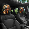 Two cute dachshund car headrest covers featuring dog illustrations on black leather seats.