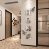 A display of six silver acrylic letter tiles H O M E on a white wall with a wooden door and light wood flooring.