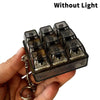 A hand holds a clear plastic keychain fidget toy with multiple black keycaps, shown without light.