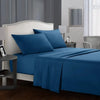 A blue bedding set featuring a fitted sheet, flat sheet, and pillowcases on a bed in a modern bedroom.