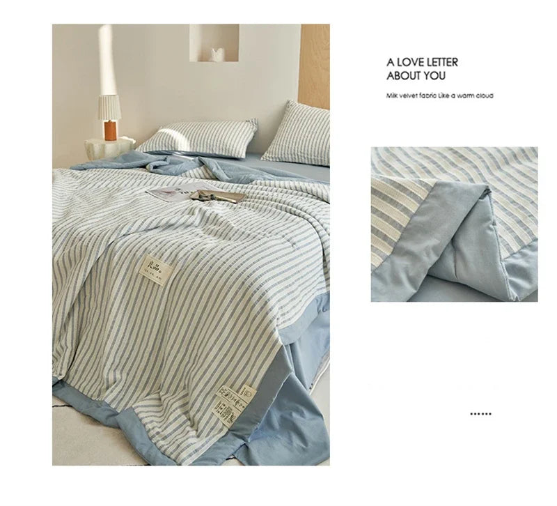 A light blue and white striped breathable summer quilt draped on a bed.