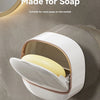 A white waterproof hanging soap holder with a clear top is mounted on a gray wall.