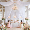 Hochzeitszeremonie-Setup mit weißem Stoffhintergrund und Blumenarrangements.