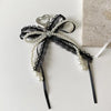 A black lace and pearl bow keychain with a heart charm