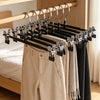 A set of five anti-slip stainless steel hangers with clips hanging on a wooden rod.