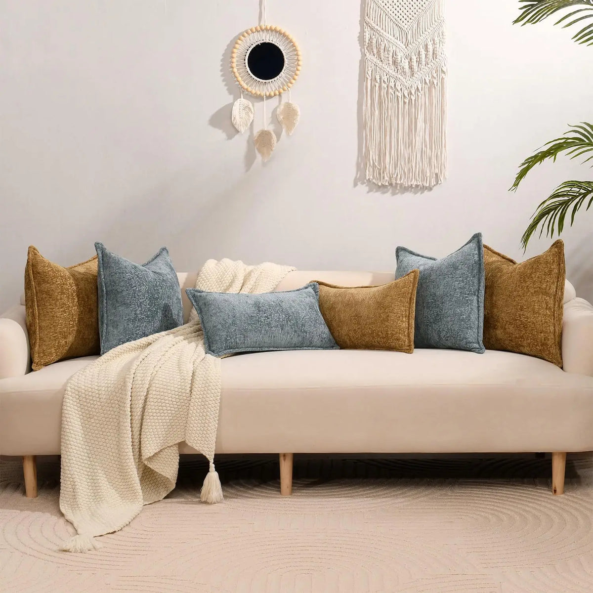 A beige sofa adorned with various textured decorative cushion covers in shades of blue, gold, and cream.