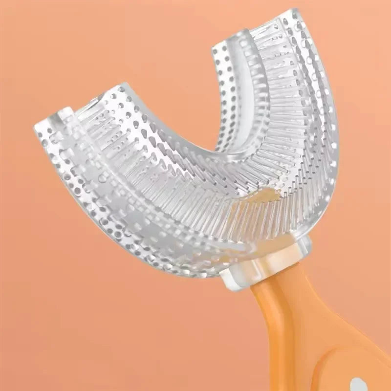 A clear, U-shaped silicone toothbrush for kids is shown attached to an orange handle.