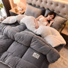 A woman is relaxing under a cozy double-sided velvet warm quilt blanket on a bed.