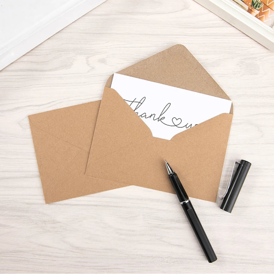 A brown kraft paper envelope is shown with a white thank you message inside, next to a black pen.