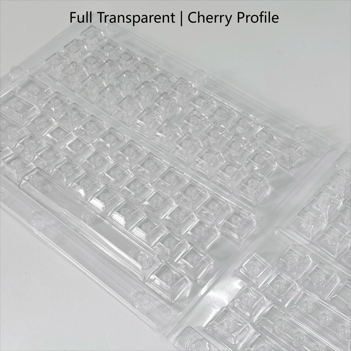 A close-up view of translucent cherry profile PC keycaps arranged in a plastic tray.