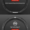 A close-up view of a black steering wheel cover showing two options: carbon-grain suede and high quality nappa pi.
