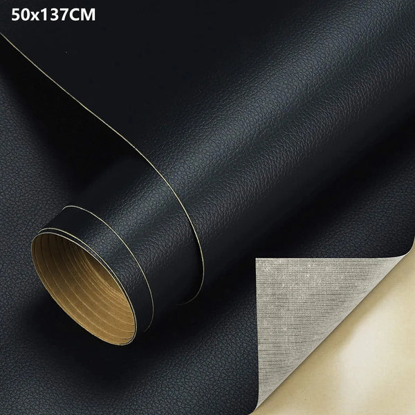 Roll of black PU leather material with a gold edge and a piece of gray fabric visible.