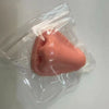 A pink squishy pimple popper fidget toy is visible inside a clear plastic bag.