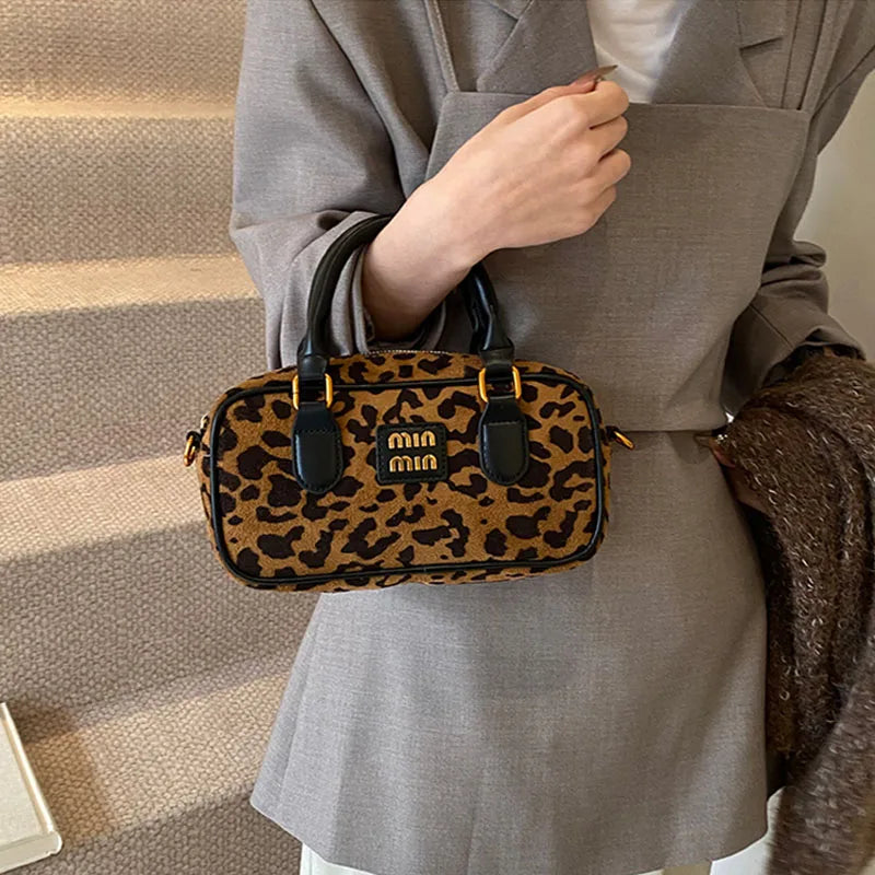 A brown leather retro leopard print hobo satchel bag carried by a person wearing a beige blazer.