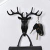 Black vintage deer head wall hook featuring antlers, used for hanging hats, scarves, and keys.