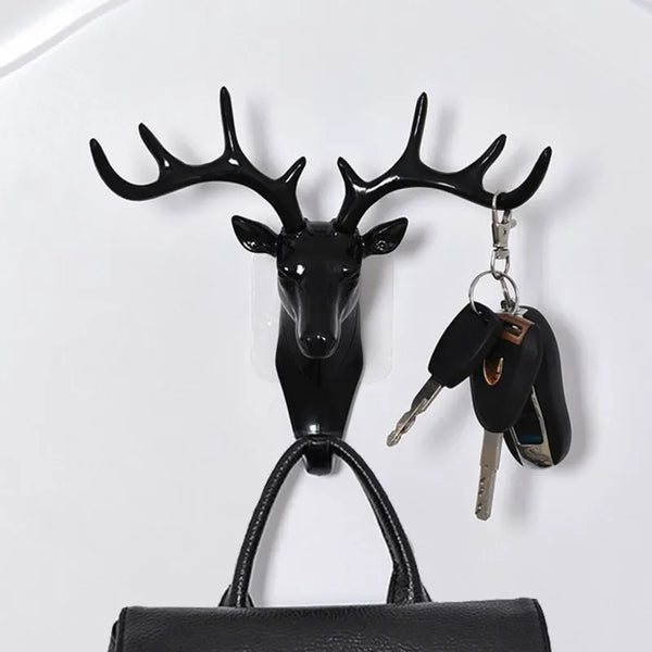 Black vintage deer head wall hook featuring antlers, used for hanging hats, scarves, and keys.