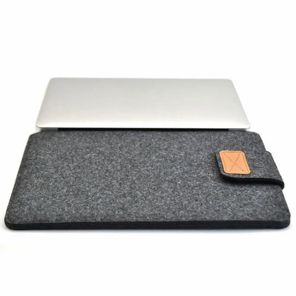 A gray felt laptop sleeve case with a white laptop visible above it.