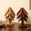A set of wooden tree-shaped heat-resistant trivets displayed on a dark wooden surface.