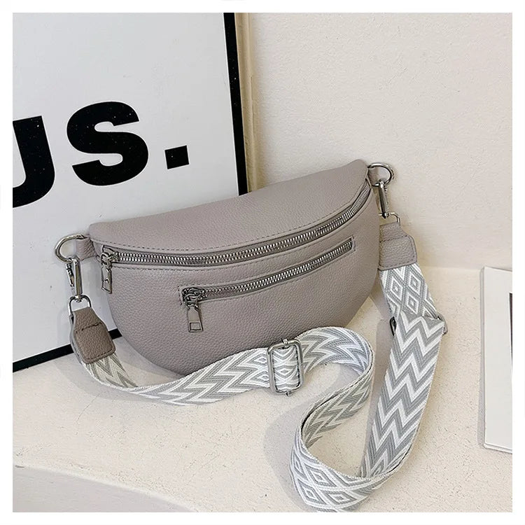 A light gray multi-pocket PU leather waist bag with a patterned strap is displayed on a white surface.