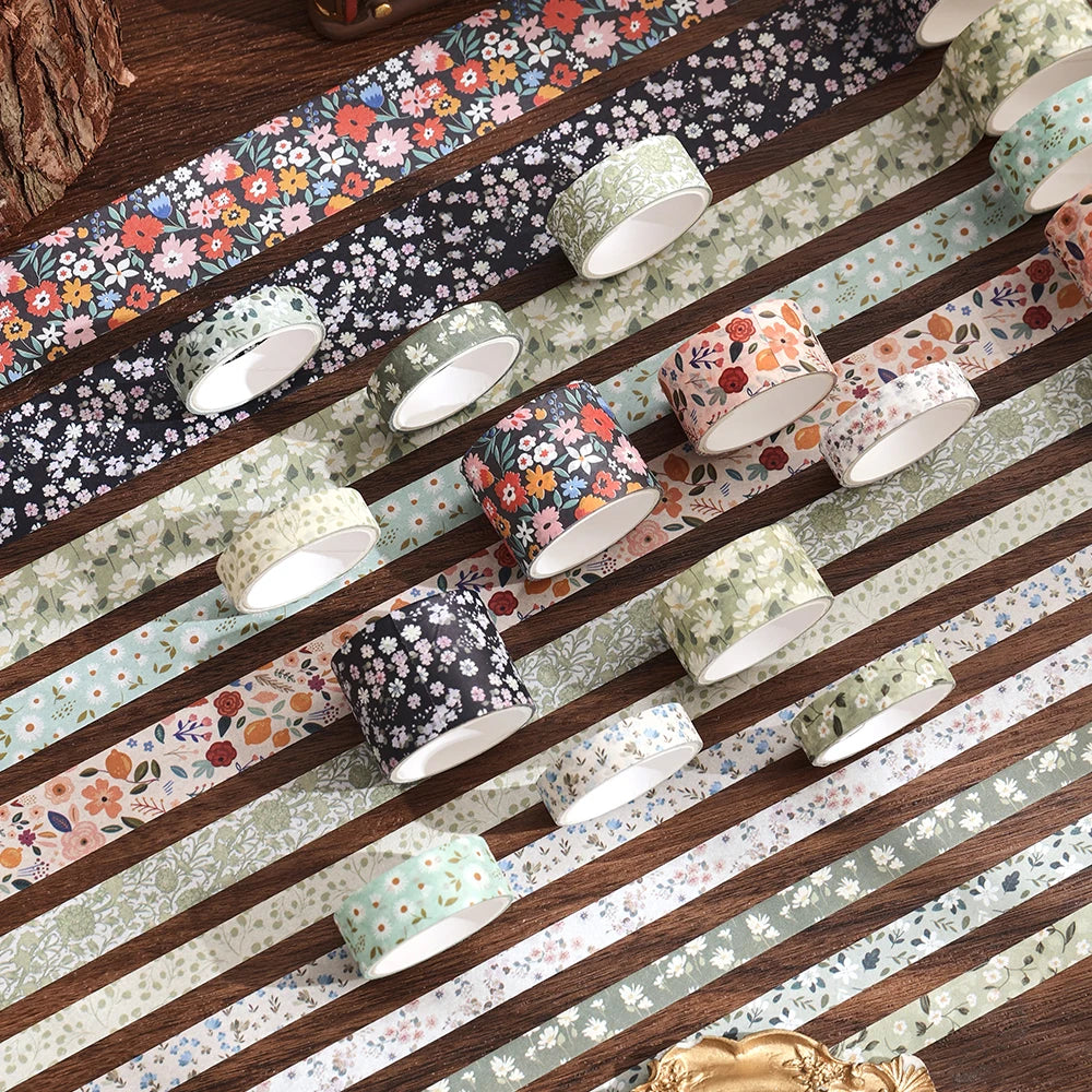Un set de ruban washi floral vintage dans divers motifs et couleurs, disposé sur une surface en bois.