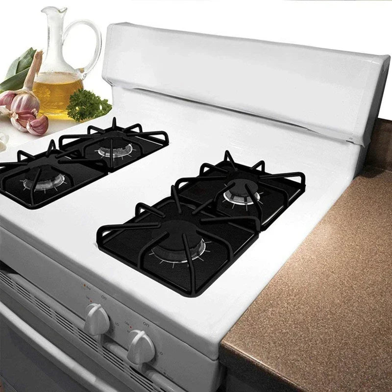 A white gas stove with four black burner protectors is shown open on a countertop.