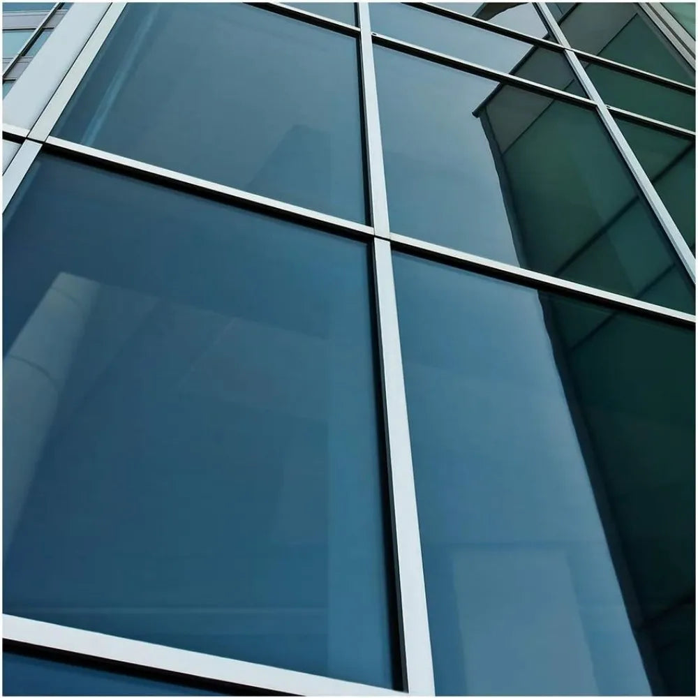 Close-up view of modern glass facade with vertical mullions and reflective blue tint.