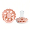 A pink silicone baby pacifier with a flower-shaped ring and a clear silicone nipple top.