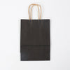 A dark brown kraft paper gift bag with natural twine handles.