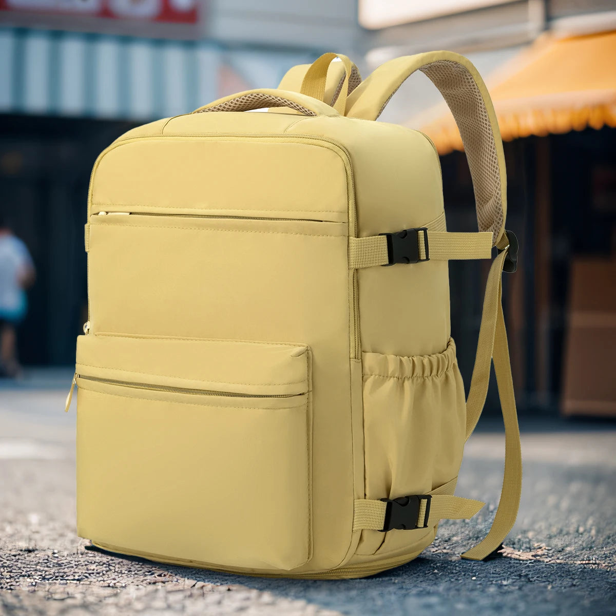 A light yellow travel and commuter backpack is shown from the back, resting on a gray surface.