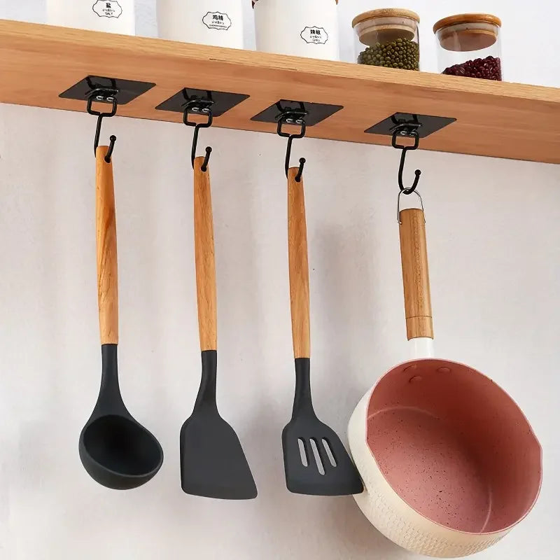 A set of wooden and black silicone spatulas hanging from a wooden rack.