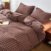 A plaid duvet cover in brown and beige tones with a checkered pattern displayed on a bed.