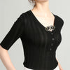 Black ribbed sweater with a V-neckline and decorative buttons