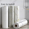 Three rolls of self-adhesive marble wallpaper showing white and gray veining, ready for installation.