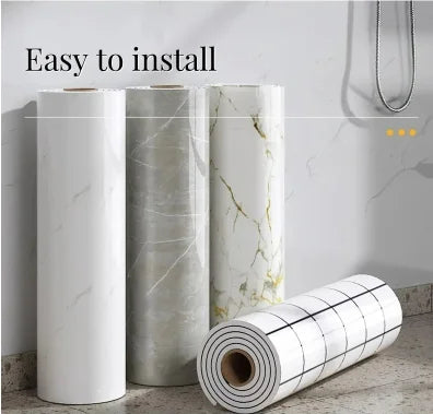 Three rolls of self-adhesive marble wallpaper showing white and gray veining, ready for installation.