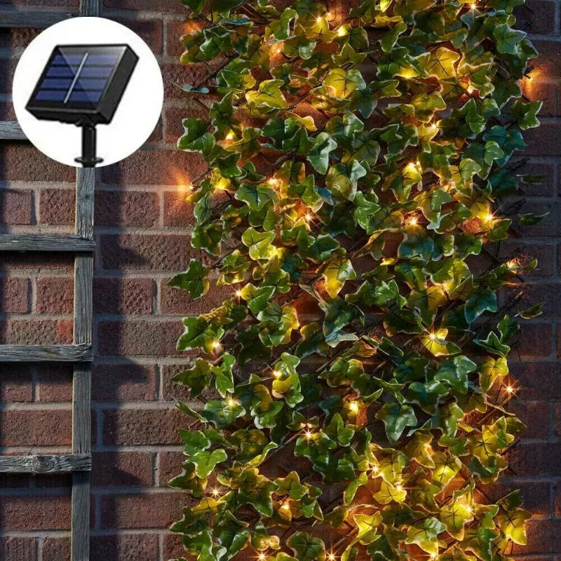 Garniture de lierre vert avec des lumières LED jaunes chaudes grimpant sur un mur de briques, à côté d'un panneau solaire.