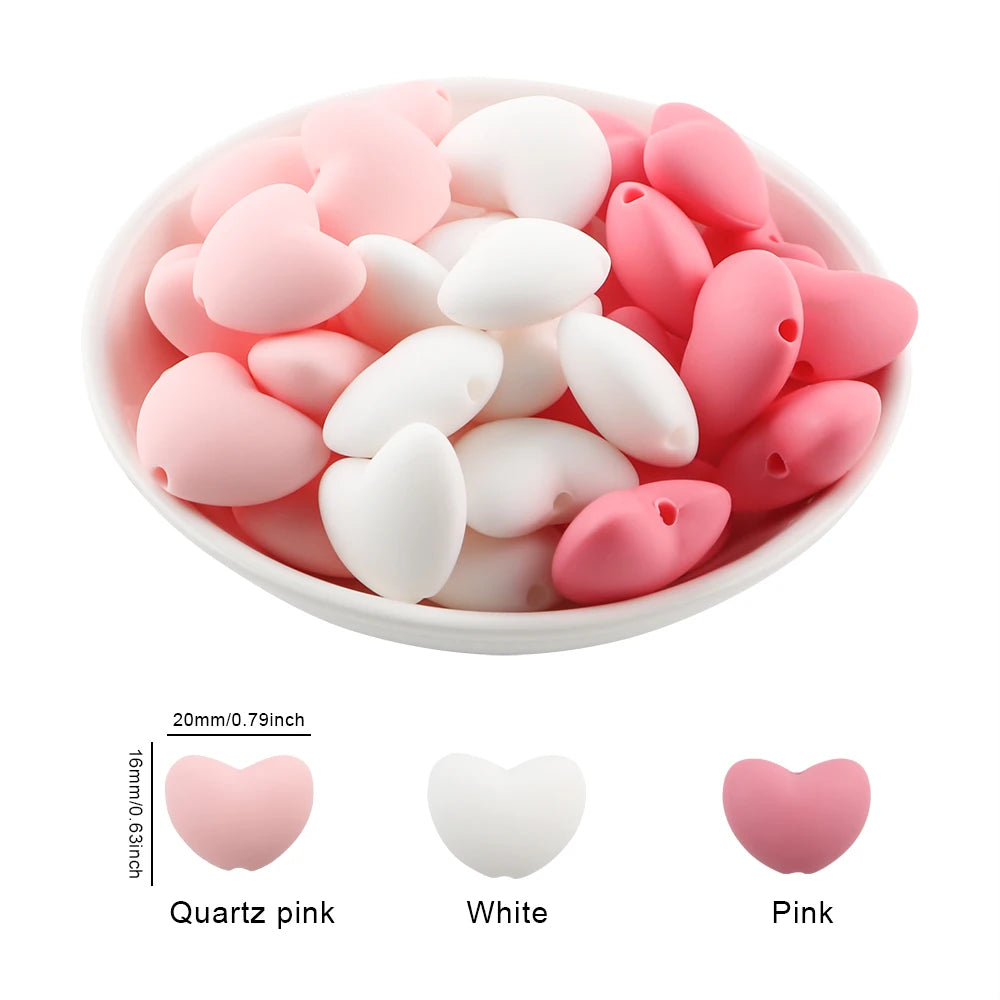 A bowl filled with ten silicone heart beads in pink and white colors for DIY jewelry making