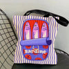 A canvas tote bag featuring a colorful print of sardines on a striped background.