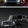 Close-up of a black Mercedes SUV with a custom demon eye LED window decal on the rear window.