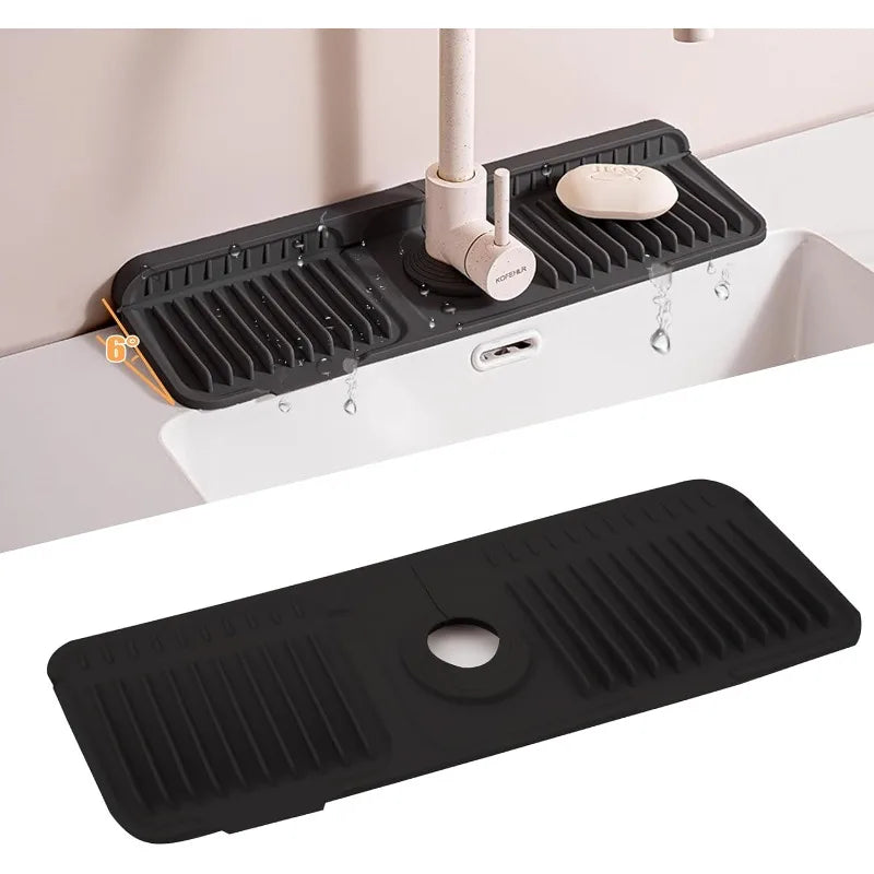 A black silicone faucet splash mat is installed in a white sink, featuring a drain and a small soap dish.