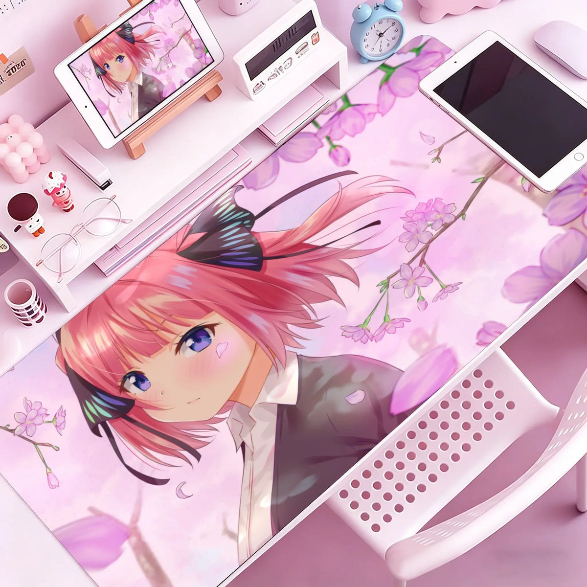 Anime character illustration on a pink mouse pad featuring pink hair and floral designs.