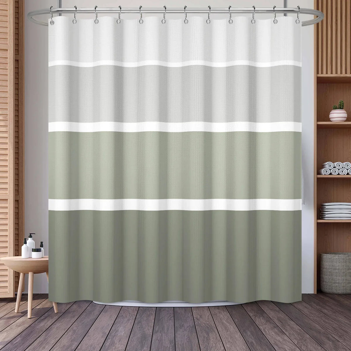 A shower curtain featuring a vertical geometric stripe pattern in shades of sage green and off-white.